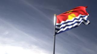 Kiribati National Flag, The national flag and flagpole looking up against a dark blue sky