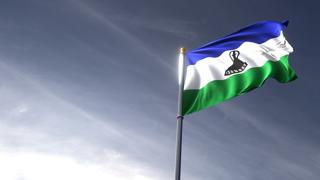 Lesotho National Flag, The national flag and flagpole looking up against a dark blue sky