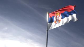 Serbia National Flag, The national flag and flagpole looking up against a dark blue sky